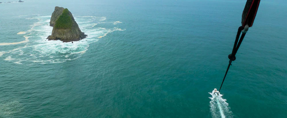        parasailing in the air 
  - Costa Rica